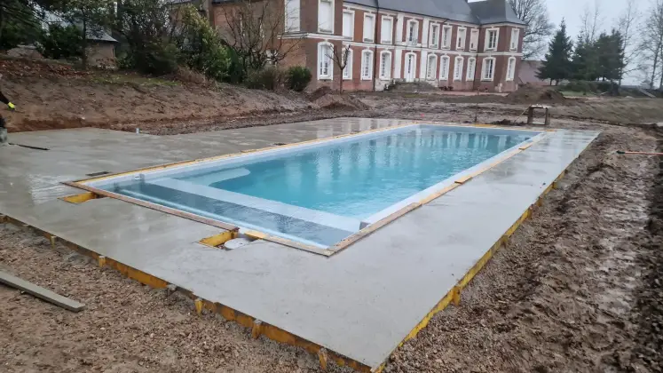 Piscine terrassée et dallée devant une demeure de caractère